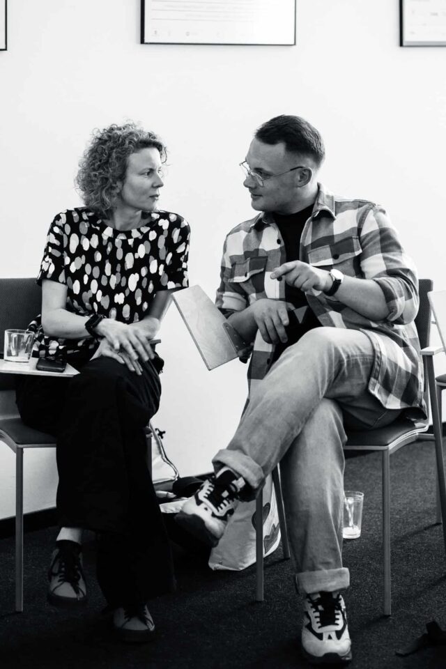 Kobieta i mężczyzna siedzą na krzesłach i rozmawiają