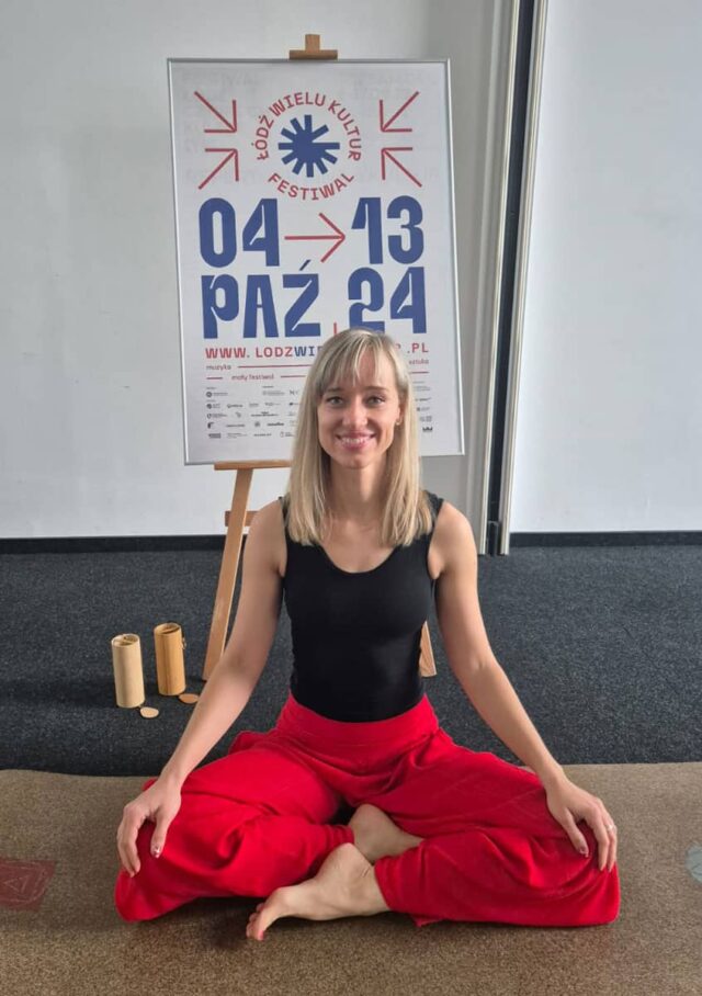 Uśmiechnięta kobieta siedzi na macie do jogi