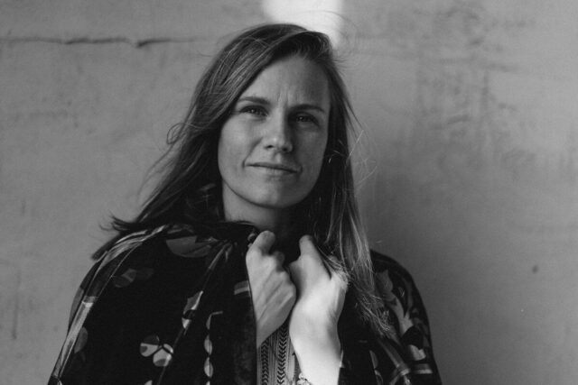 Kobieta z długimi włosami na tle ściany