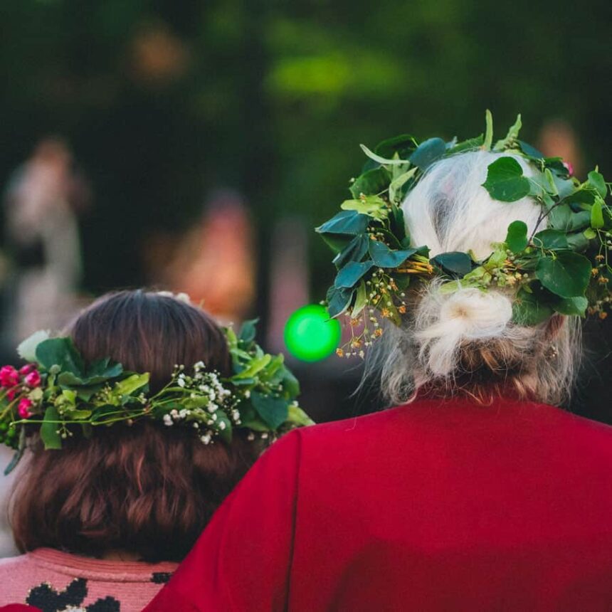 Starsza kobieta i dziecko w wiankach odwrócone tyłem