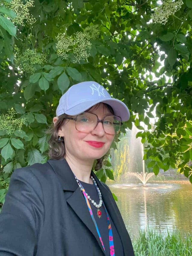 Kobieta w czapce z daszkiem na tle parku