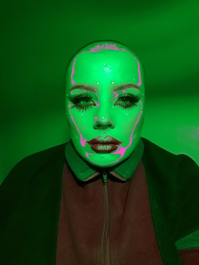 Portret młodej łysej mocno umalowanej kobiety w kosmicznym zielonym świetle