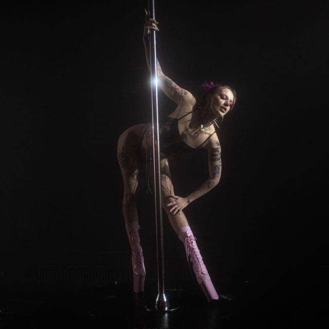 Kobieta w skąpym stroju tańcząca na rurze