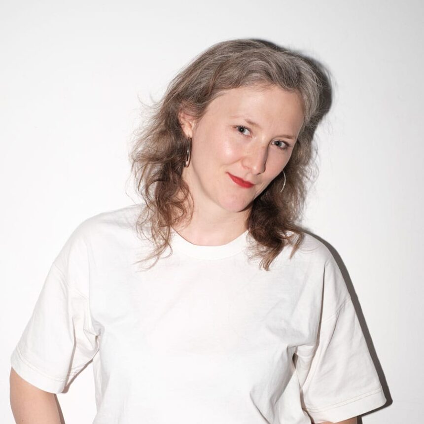 Kobieta w białym t-shircie na tle białej ściany