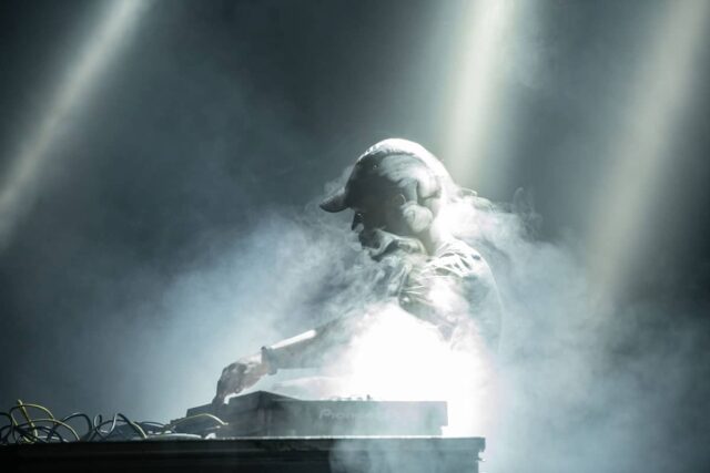 czarny mężczyzna grający na konsoli, dym dookoła