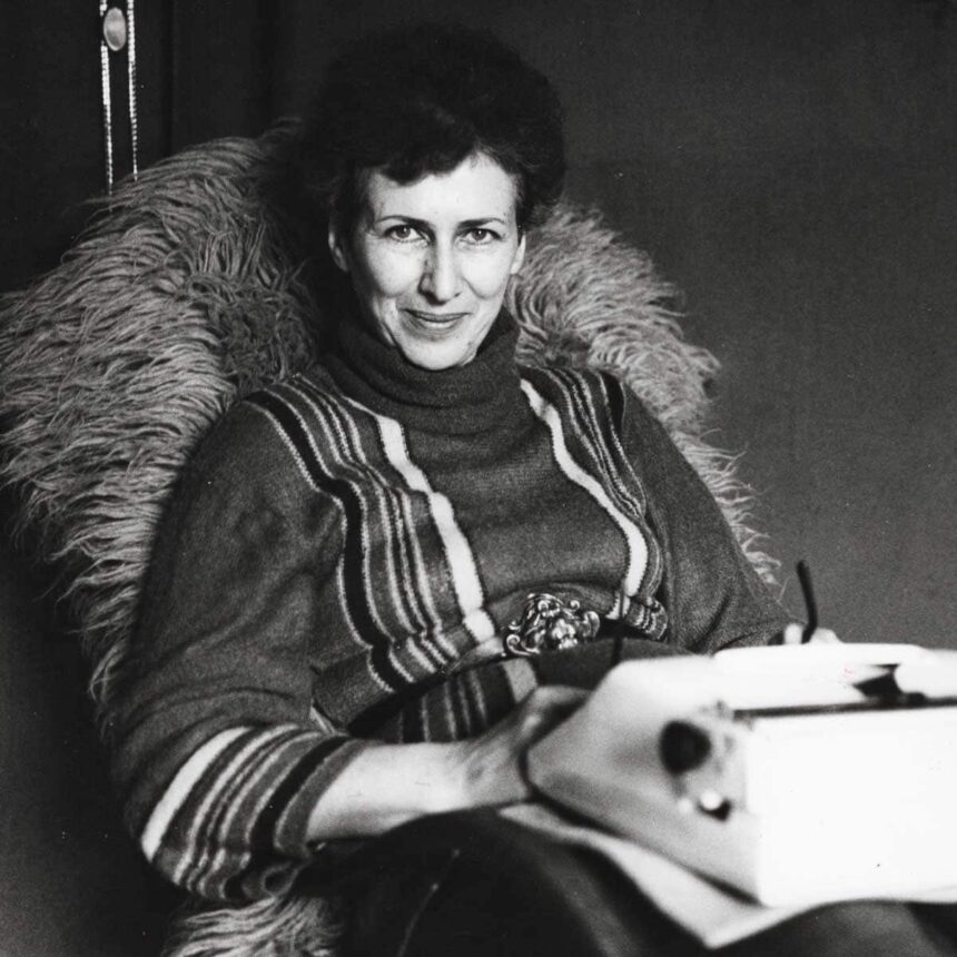 Kobieta Joanna Kulmowa siedząca w fotelu z maszyną do pisania na kolanach