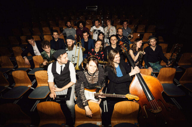 Muzycy z instrumentami siedzą na widowni