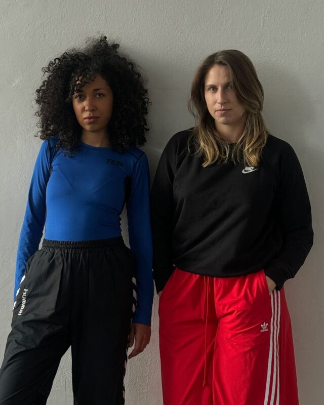 Dwie kobiety, czarna i biała na tle ściany