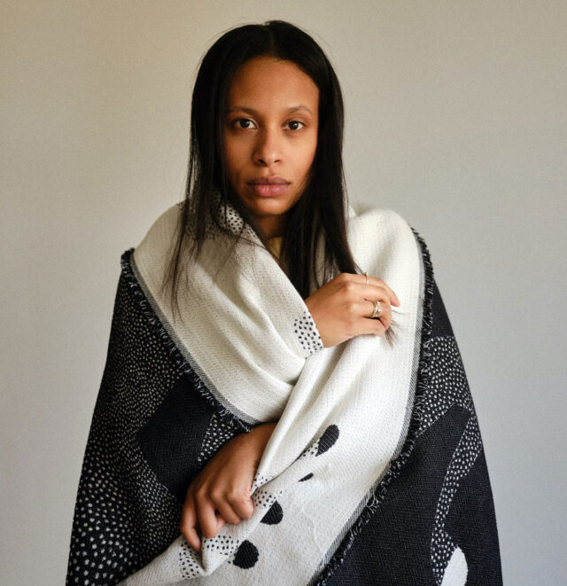 Czarnoskóra kobieta otulona kocem