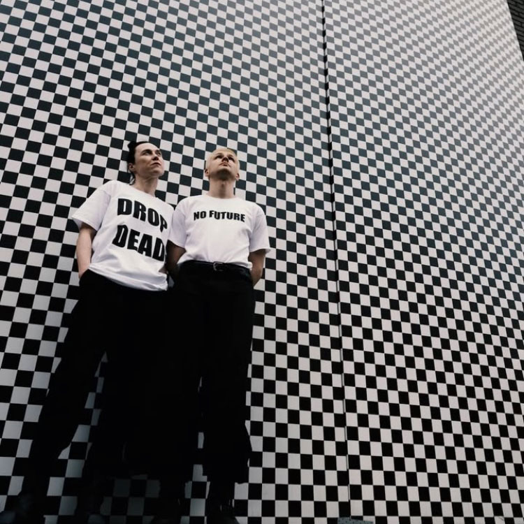 Kobieta i mężczyzna w białych t-shirtach na tle czarno-białej ściany