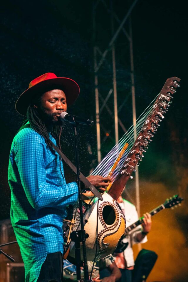 Czarny mężczyzna gra na egzotycznym instrumencie