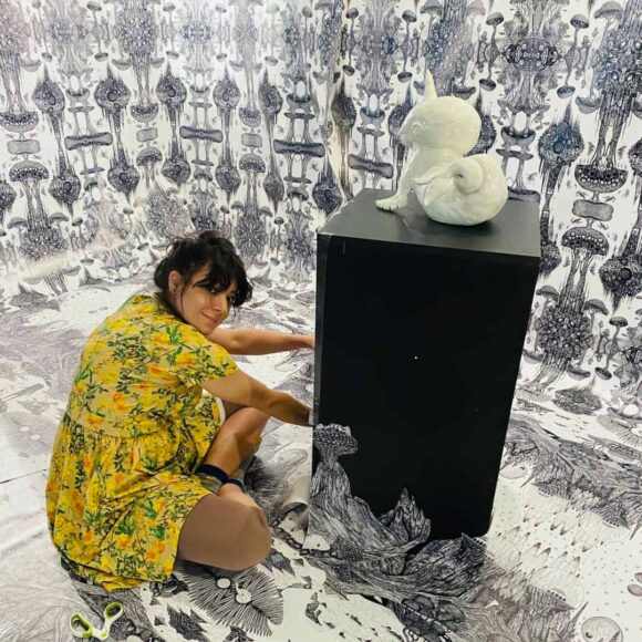 Kobieta z rzeźbą na postumencie w czarno-białej przestrzeni