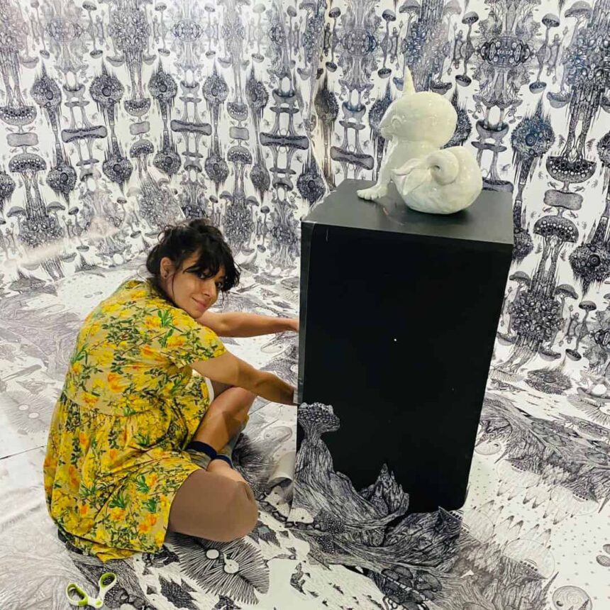 Kobieta z rzeźbą na postumencie w czarno-białej przestrzeni