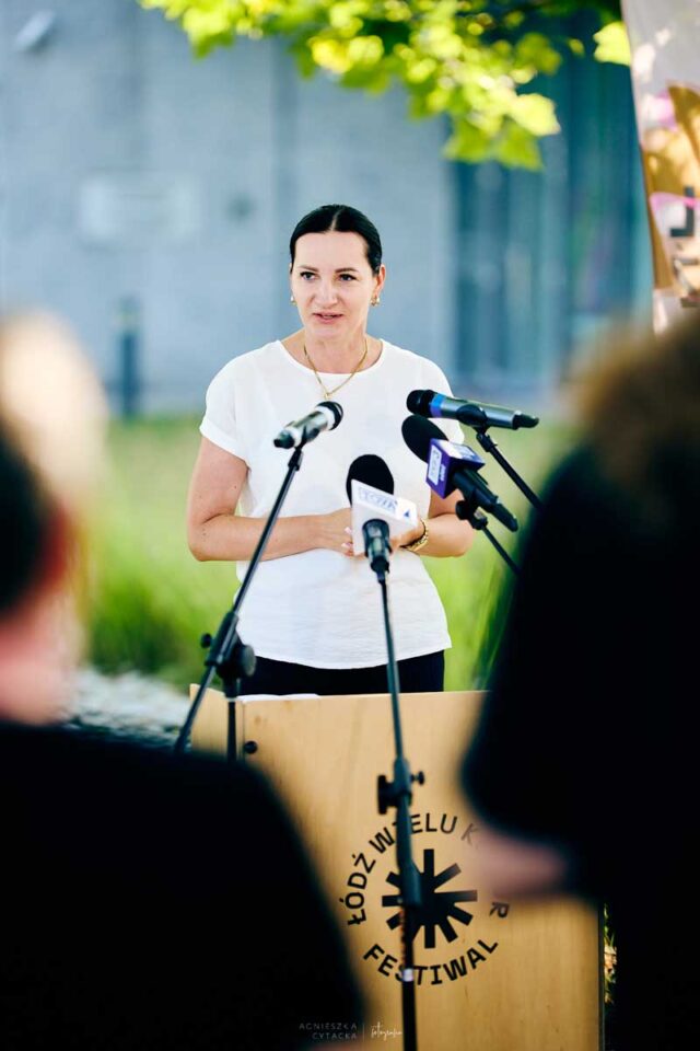 Wiceprezydentka przy mownicy, na pierwszym planie ludzie tyłem