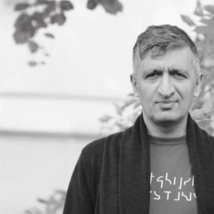 Czarno biały portret mężczyzny na tle gałęzi drzew