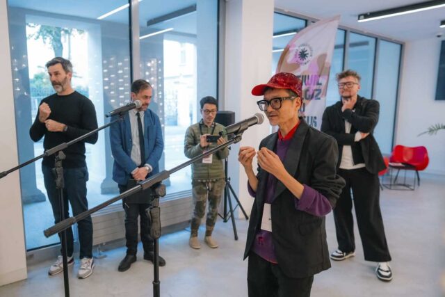 Wietnamski artysta przy mikrofonie, w tle inni ludzie