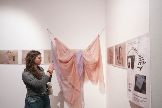 Kobieta robiąca zdjęcie tkaninie i pracom na ścianach