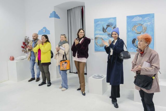 Grupa osób w jasnej przestrzeni z niebeskimi praca na ścianach