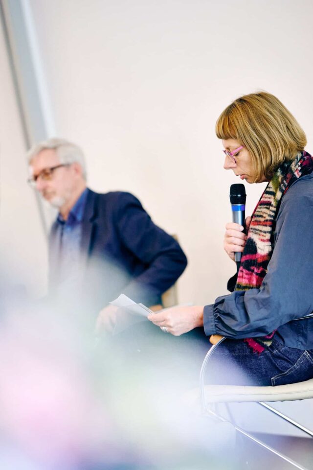 Kobieta z mikrofonem na pierwszym planie, w tle mezczyzna