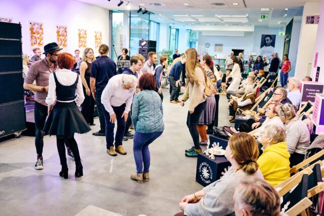 dużo ludzi w hallu budynku, tańczą, siedzą