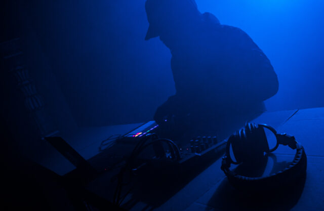 zarys postaci DJa w niebieskim świetle