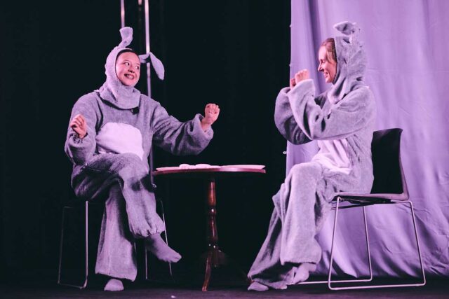 Dwie młode kobety przebrane za króliki na scenie