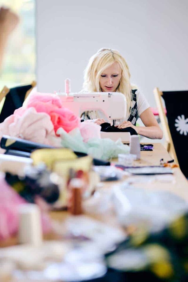 Młoda kobieta blondynka przy maszynie do szycia