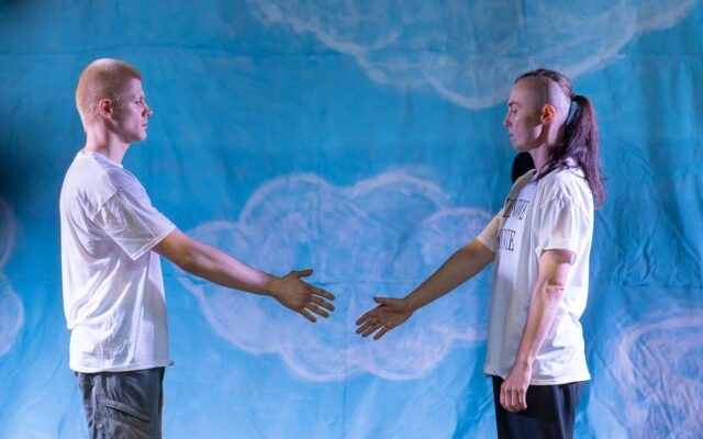 dwie osoby w białych T-shirtach wyciągające do siebie dłonie