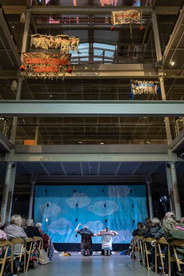 dwie klęczące osoby w industrialnej przestrzeni muzeum włókiennictwa