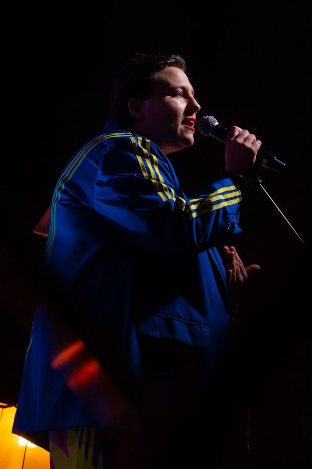 Kobieta ubrana w bluzę dresową przy mikrofonie